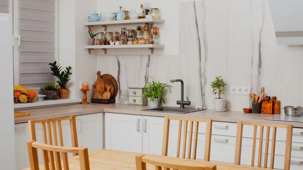 Una cocina con una escalera y una mesa con una planta encima.
